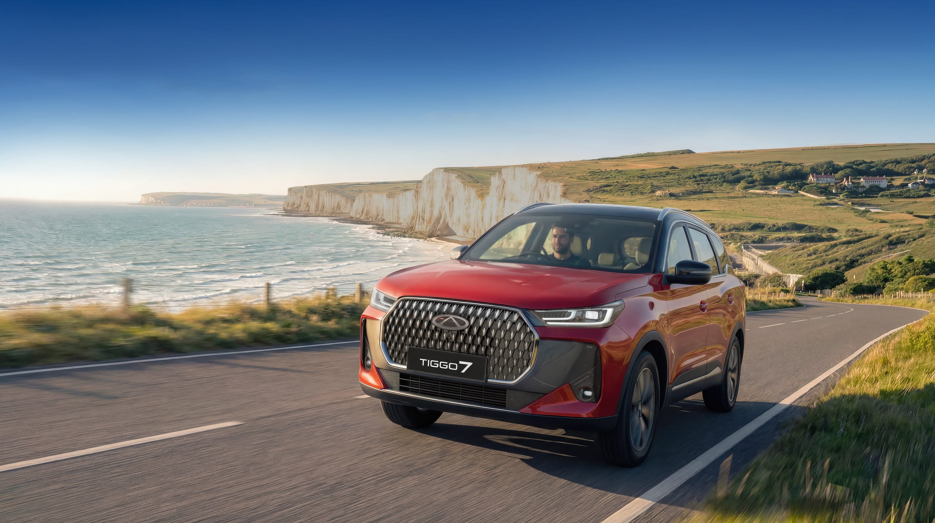 An SUV tracing a coastal road above an emerald reef — the kind of drive a Fiji weekend is made of.